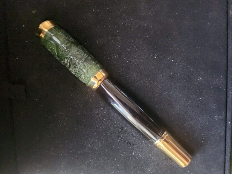Luxury pen with green and gold design.