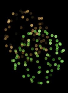 Green and gold bokeh lights on black.