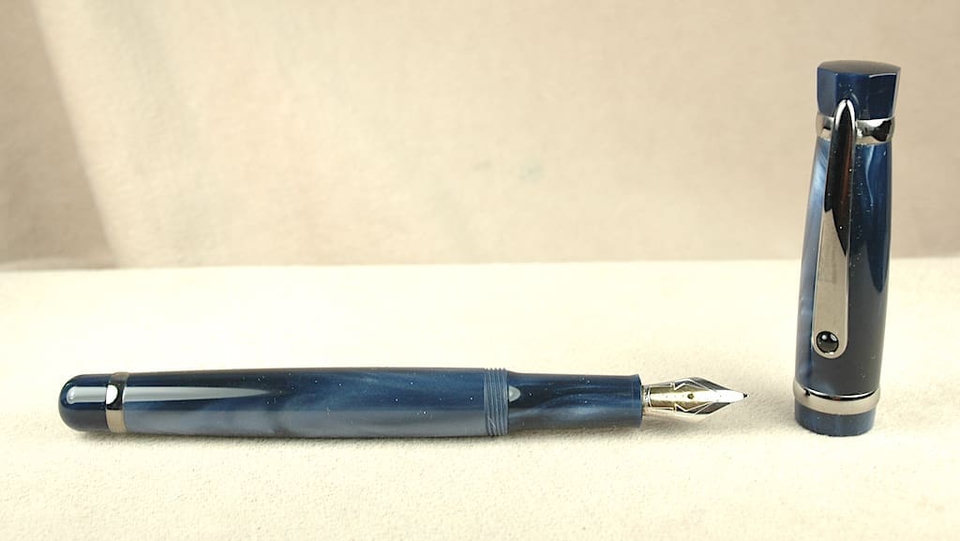 Blue fountain pen with detached cap.