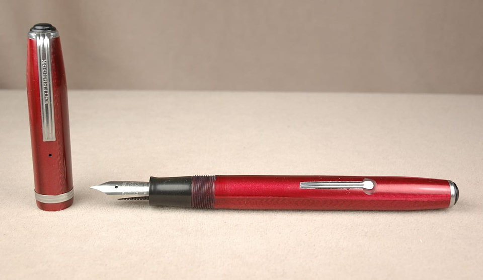 Red fountain pen with detachable cap.