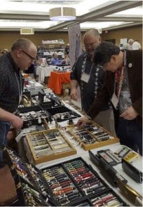 People browsing pens at a trade show.