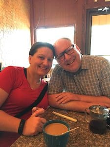 Two people smiling at a restaurant table.