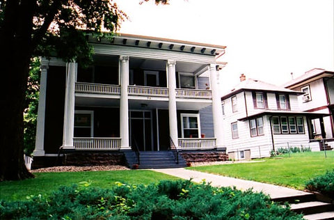 Large house with columns and porch steps.
