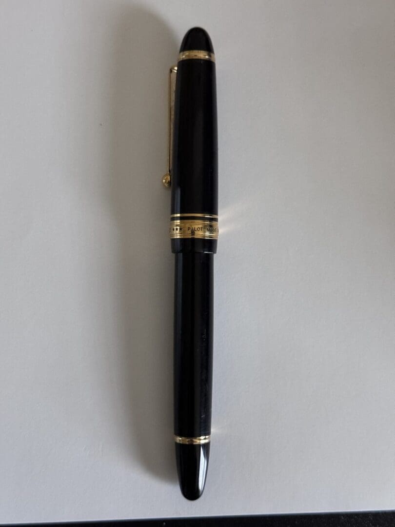 Black pen with gold accents on paper.