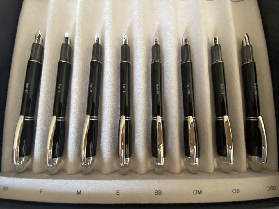 Set of nine black fountain pens displayed.