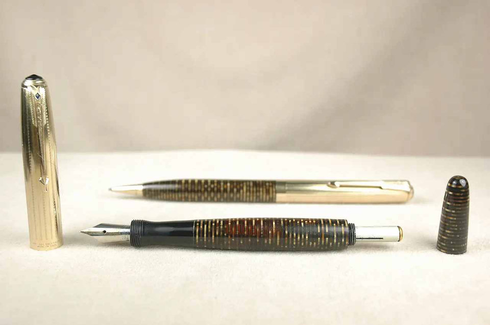Two pens placed horizontally on a light surface.