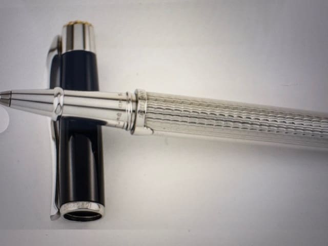 A sleek silver and black fountain pen on a white surface.
